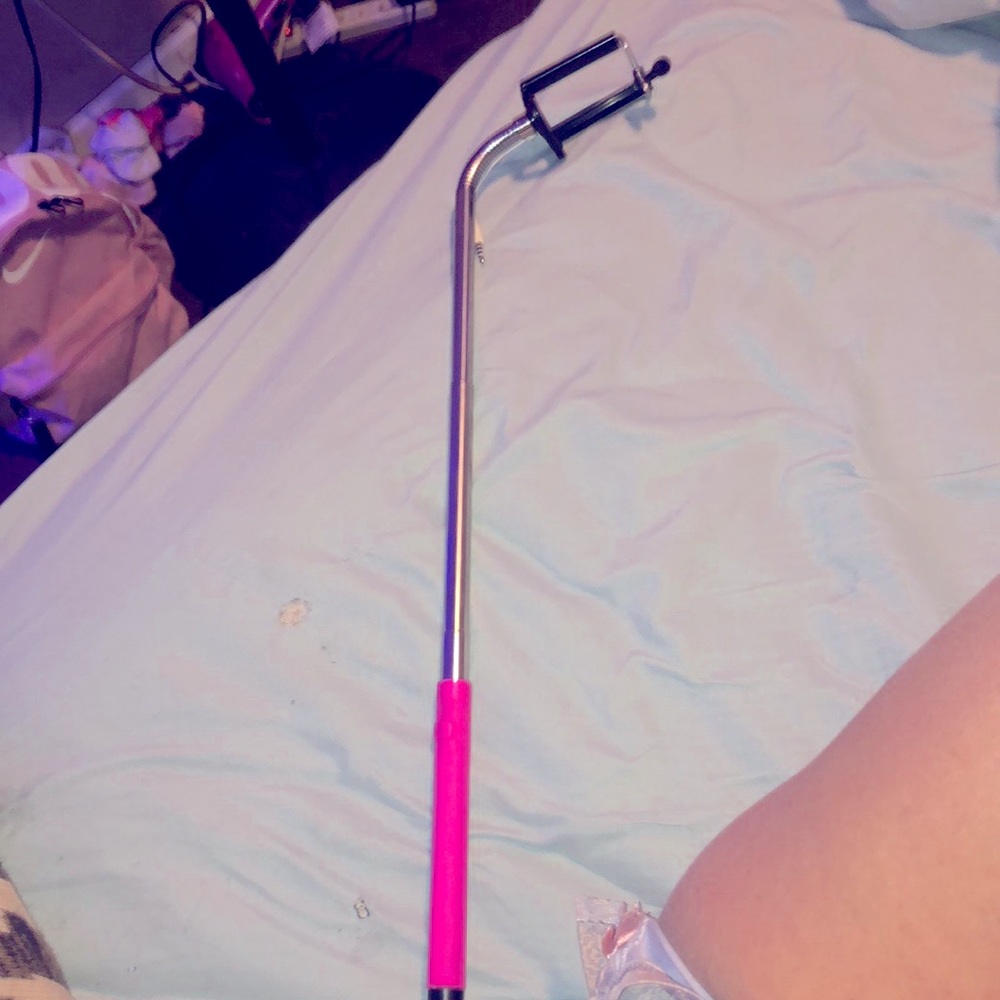 Pink selfie stick with aux cord and button